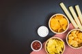 Potato chips and snacks on black slate table, top view Royalty Free Stock Photo