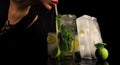 Party and summer vacation. Cocktail with ice cube for young girl on black. woman drink mojito with lime and