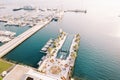 Party tables stand on a long pier with a swimming pool and yachts moored to the side. Drone Royalty Free Stock Photo