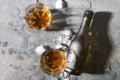 Party time.Alcohol drinks and bottle with brandy, pieces of ice on gray table Royalty Free Stock Photo