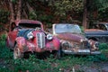 Pasanauri, Georgia - 06.10.2018: Old rusted out scrap retro cars that has been abandoned in forest woods