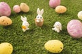 Paschal eggs with cute bunnies on the green lawn