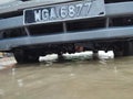 Pasir Puteh, Kelantan - February 27, 2022 : An road under water. Flooded cars on streets of the village. flood disaster