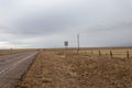 Pass with care sign on side of rural country road with yellow grass on overcast day Royalty Free Stock Photo