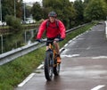 Passable bike so called fat bike on city street and cyclist in red Royalty Free Stock Photo