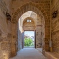 Passage at Al-Muayyad Bimaristan hospital historic building with stone bricks wall, arches, and entrance door, Cairo, Egypt