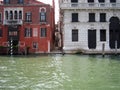 Passage between ancient houses of different colors near the water in Venice, Italy