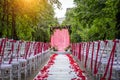 Passage between the chairs, decorated with rose petals leads to the wedding arch. Solemn wedding registration in the park Royalty Free Stock Photo