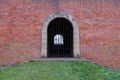 A passage closed by a lattice in an old brick fortress wall. Antique brickwork