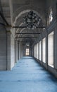 Passage in Nuruosmaniye Mosque with columns, arches and floor covered with blue carpet lighted by side windows, Istanbul, Turkey Royalty Free Stock Photo