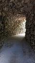 Passage tunnel wall and ceiling of stones light at the end of the tunnel