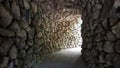 Passage tunnel wall and ceiling of stones light at the end of the tunnel