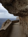 A passage under the overhanging heavy rocks and above the deep blue abyss of the Meditarranean Royalty Free Stock Photo