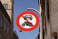 The passage of vehicles and motorcycles is prohibited. Round red and white traffic sign in a city with blue sky background. Royalty Free Stock Photo