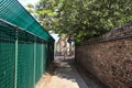 Passageway bordered by a brick wall with a tree Royalty Free Stock Photo