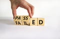 Passed or failed symbol. Businessman turns wooden cubes and changes the word `failed` to `passed` on a beautiful white table,