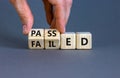 Passed or failed symbol. Businessman turns wooden cubes and changes the word `failed` to `passed` on a beautiful grey table, g