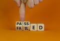 Passed or failed symbol. Businessman turns wooden cubes and changes the word `failed` to `passed` on a beautiful orange table,