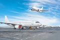 Passenger aircraft, airplane parked on service before departure. at the airport, other plane push back tow. One fly in the sky. Royalty Free Stock Photo