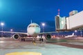 Passenger aircraft arrives at the terminal by night flight, gangway waiting for disembarking passengers Royalty Free Stock Photo