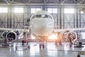 Passenger aircraft on maintenance of engine and fuselage repair in airport hangar.