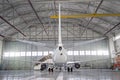 Passenger aircraft on maintenance of engine and fuselage repair in airport hangar. Rear view of the tail. Royalty Free Stock Photo