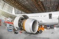 Passenger aircraft on maintenance of engine and fuselage repair in airport hangar. View airplane engine. Royalty Free Stock Photo