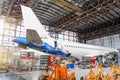 Passenger aircraft on maintenance of engine repair, among the jacks, a view of the tail and the rear of the fuselage in airport ha Royalty Free Stock Photo