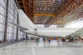 Passenger aircraft on maintenance of repair, a view of the tail and the rear of the fuselage in airport hangar.