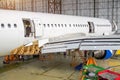 Passenger aircraft on maintenance, a view of the rear of the fuselage in airport hangar. Royalty Free Stock Photo