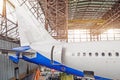 Passenger aircraft on maintenance, a view of the tail and the rear of the fuselage in airport hangar. Royalty Free Stock Photo