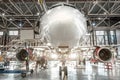 Passenger aircraft, nose close up. Maintenance of engine and fuselage repair in airport hangar Royalty Free Stock Photo