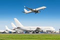 Passenger aircraft row, airplane parked on service before departure at the airport, other plane push back tow. Airplane landing to Royalty Free Stock Photo