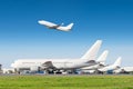 Passenger aircraft row, airplane parked on service before departure at the airport, other plane push back tow. One take off from t Royalty Free Stock Photo