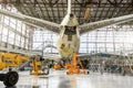 Passenger aircraft on service in an aviation hangar rear view of the tail, on the auxiliary power unit. Royalty Free Stock Photo