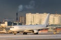 Passenger aircraft taking off at sunset in winter day. Airplane turns on runway