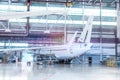 Passenger aircraft under maintenance. Checking mechanical systems for flight operations. White jet plane in the hangar