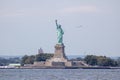 Passenger airliner soaring past the iconic Statue of Liberty in New York City