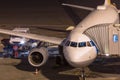 Passenger airplane at an aiport gate at night