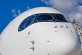 Passenger airplane nose cockpit in blue clouds sky Royalty Free Stock Photo