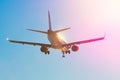 Passenger airplane flies near the sun glare with a color rainbow gradient on landing. Royalty Free Stock Photo