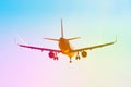 Passenger airplane flies near the sun glare with a color rainbow gradient on landing, with the wings of a steam jet vortex. Royalty Free Stock Photo