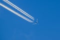 Passenger airplane in flight - blue sky - 4 engine plane - engine contrails - chemtrails Royalty Free Stock Photo