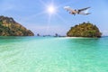 Passenger airplane flying above small limestone island in tropical andaman sea Royalty Free Stock Photo