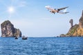 Passenger airplane flying above small limestone island in tropical andaman sea with sunlight. Royalty Free Stock Photo