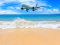 Passenger airplane flying above tropical beach in Phuket, Thailand. Amazing view of blue sea and golden sand. Royalty Free Stock Photo