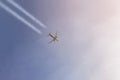 Passenger airplane flying high in clear sky leaving white trails. Big plane flying during sunset time with dramatic sky on backgro Royalty Free Stock Photo