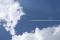 A passenger airplane flying high in the sky among the clouds. Air liner leaving a trace of exhaust gases glowing in the sun. Ecolo