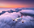 Passenger airplane flying over clouds at sunset. Aircraft Royalty Free Stock Photo