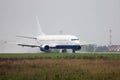 Passenger airplane heading on the runway with extended spoilers in heavy rain